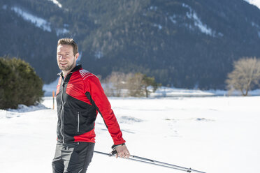 Österreich, Tirol, Achensee, Porträt eines lächelnden Mannes beim Skilanglauf - MKFF00463