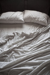 Ungemachtes Bett mit weißen Laken - MINF10878