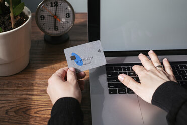 Woman using laptop and credit card for online shopping, partial view - MOMF00643