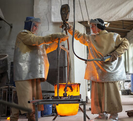 Art foundry, Foundry workers lifting mold - BFRF01988