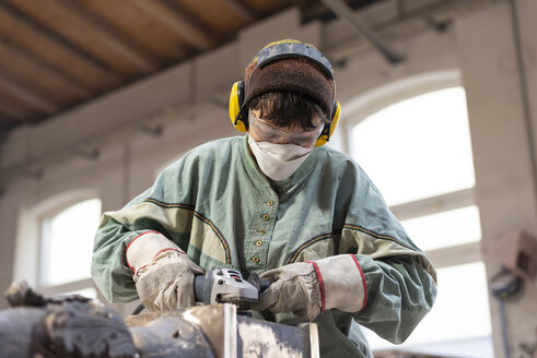 Art foundry, Female foundry worker polishing metal - BFRF01998