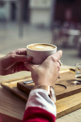 Frauenhände halten eine Tasse Kaffee, Nahaufnahme, lizenzfreies Stockfoto