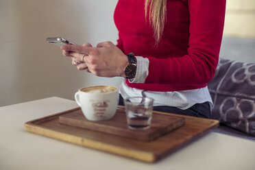 Frau mit Smartphone in einem Café, Teilansicht - ACPF00496