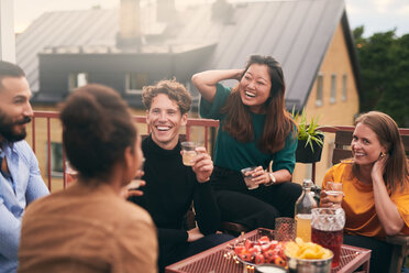 Fröhliche Freunde unterhalten sich bei einem geselligen Beisammensein auf der Terrasse - MASF11566