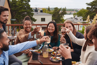 Glückliche Freunde stoßen auf der Terrasse mit Getränken an - MASF11576