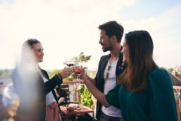 Smiling friends toasting drinks while partying on terrace - MASF11583