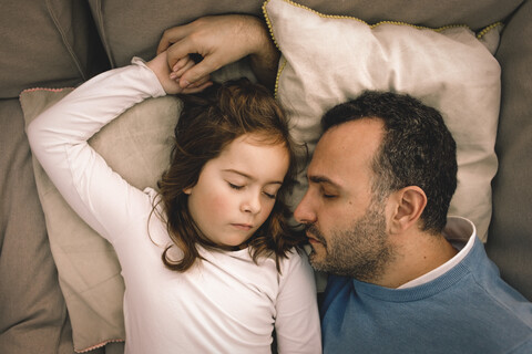 Unmittelbar über der Aufnahme von Vater und Tochter, die zu Hause auf der Couch schlafen, lizenzfreies Stockfoto