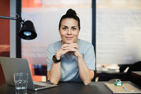 Porträt einer selbstbewussten, kreativen Geschäftsfrau, die am Schreibtisch im Büro sitzt - MASF11700