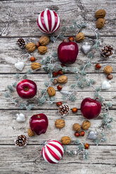 Weihnachtsäpfel, Walnüsse, Haselnüsse und Weihnachtsdekoration auf Holz - LVF07888