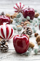 Weihnachtsäpfel, Walnüsse, Haselnüsse und Weihnachtsdekoration auf Holz - LVF07889