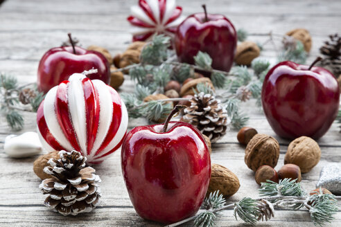 Weihnachtsäpfel, Walnüsse, Haselnüsse und Weihnachtsdekoration auf Holz - LVF07890