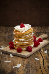 Pancakes made of almond flour with raspberries, greek yogurt and coconut flakes on wooden board - LVF07891