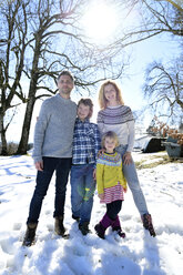 Porträt einer glücklichen Familie auf einem Feld im Winter - ECPF00595