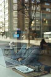 Mature businesswoman with glass of tea laptop in a cafe - JPF00359