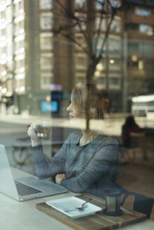 Reife Geschäftsfrau mit einem Glas Tee Laptop in einem Café - JPF00359