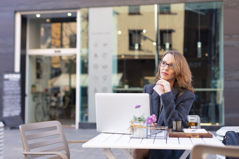 Reife Geschäftsfrau mit Laptop in einem Straßencafé - JPF00364