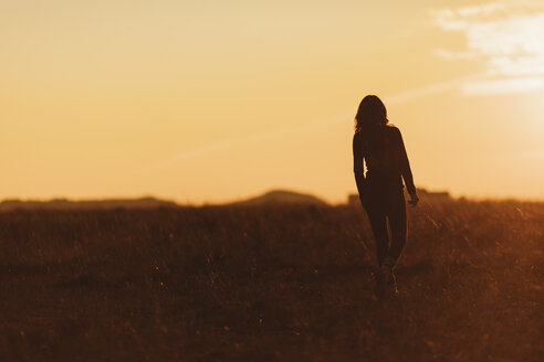 Frau beim Spaziergang in der Natur bei Sonnenuntergang - JPF00365