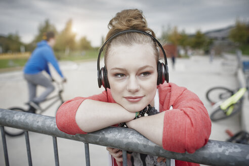 Porträt eines Teenagers mit Kopfhörern in einem Skatepark - RORF01811