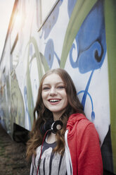 Porträt eines glücklichen Teenagers an einem bemalten Zugwaggon - RORF01817