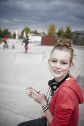 Porträt eines lächelnden Teenagers in einem Skatepark - RORF01833