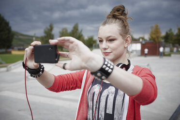 Teenager-Mädchen macht ein Selfie in einem Skatepark - RORF01834