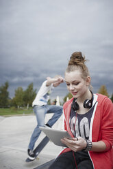 Jugendliches Mädchen benutzt ein Tablet in einem Skatepark - RORF01835