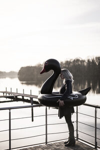 Geschäftsfrau mit schwimmendem Schwan auf einem Hausboot stehend - MJRF00094