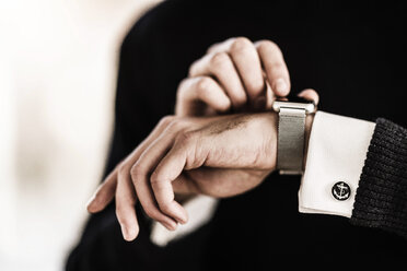 Businessman checking the time on his smartwatch - MJRF00122