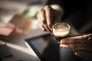 Geschäftsmann hält eine Tasse Kaffee in seinem Büro - MJRF00124