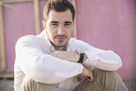 Portrait of young man in front of pink wall stock photo