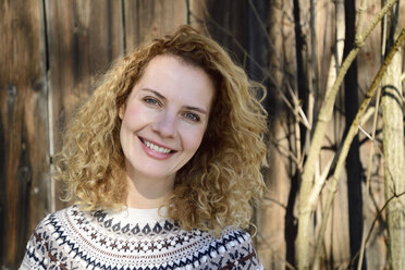 Blonde woman with curly hair smiling, norwegian sweater - ECPF00606