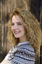 Blonde woman with curly hair smiling, norwegian sweater - ECPF00608