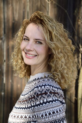 Blonde woman with curly hair smiling, norwegian sweater - ECPF00609