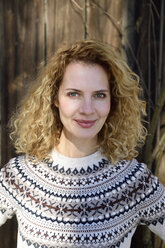 Blonde woman with curly hair smiling, norwegian sweater - ECPF00610