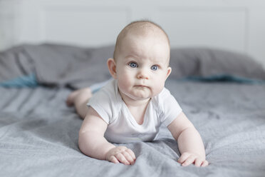 Portrait of baby boy lying on bed - STBF00271