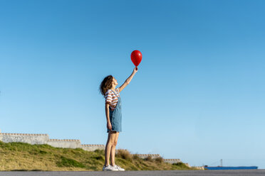 Hand holding red card against blue sky - Stock Image - F005/1647 - Science  Photo Library