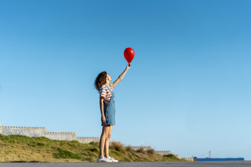 Junge Frau hält roten Ballon - AFVF02620