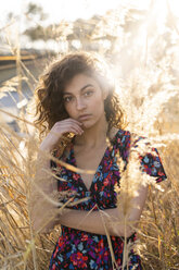 Pensive young woman standing in meadow, portrait - AFVF02626