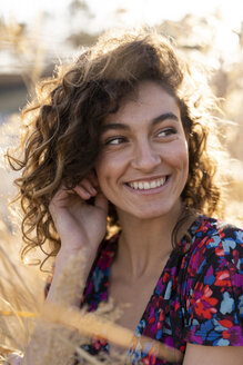 Porträt einer jungen Frau auf einer Wiese stehend, lachend - AFVF02627