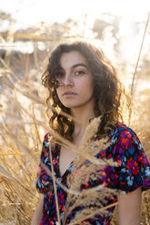 Portrait of a serious young woman, standing in meadow - AFVF02628