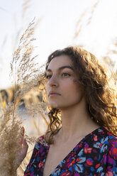 Portrait of a serious young woman, standing in meadow - AFVF02630