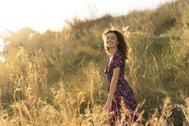 Happy young woman standing in summer meadow - AFVF02640