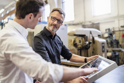 Zwei Kollegen arbeiten in einer Fabrik an einer Solarzelle - DIGF06239