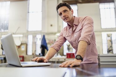 Man using laptop in factory - DIGF06262