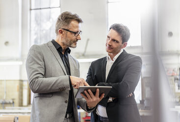 Two businessmen with tablet discussing in a factory - DIGF06283