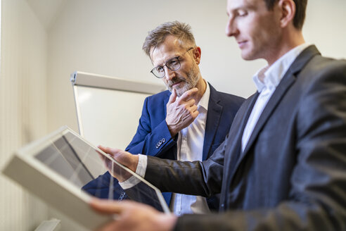 Two businessmen in office looking at solar cell - DIGF06316