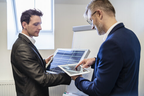 Two businessmen in office with solar cell and tablet - DIGF06318