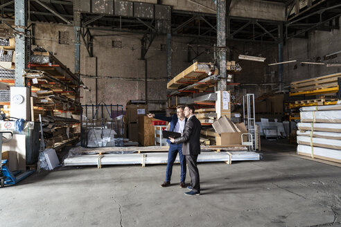 Two businessmen with folder talking in an old storehouse - DIGF06327