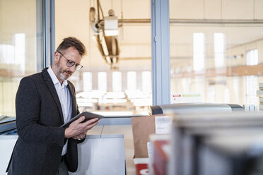 Geschäftsmann mit Tablet am Fenster mit Fabrik Hintergrund - DIGF06354