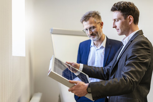 Two businessmen in office with solar cell discussing - DIGF06378